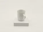 KAHLA Pronto Line Porzellanbecher in Warm Gray mit Henkel auf hellem Sockel